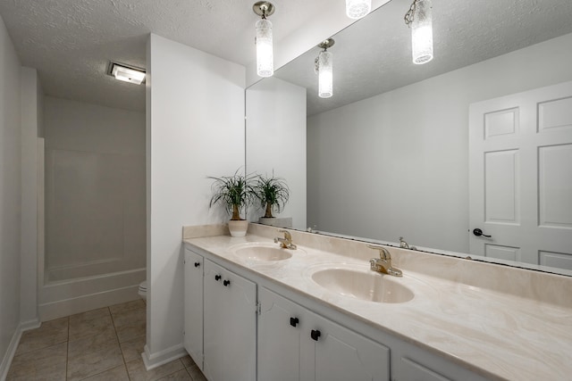 bathroom with vanity, tile patterned flooring, a textured ceiling, and toilet