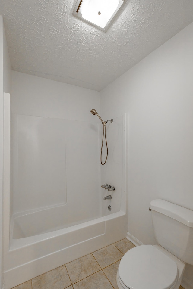 bathroom featuring toilet, shower / bathing tub combination, a textured ceiling, and tile patterned flooring