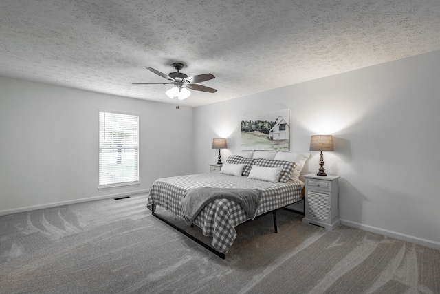 bedroom with ceiling fan, a textured ceiling, and carpet