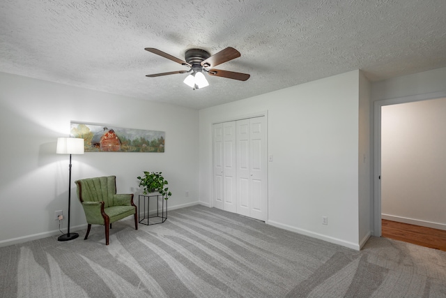 unfurnished room with a textured ceiling, light carpet, and ceiling fan