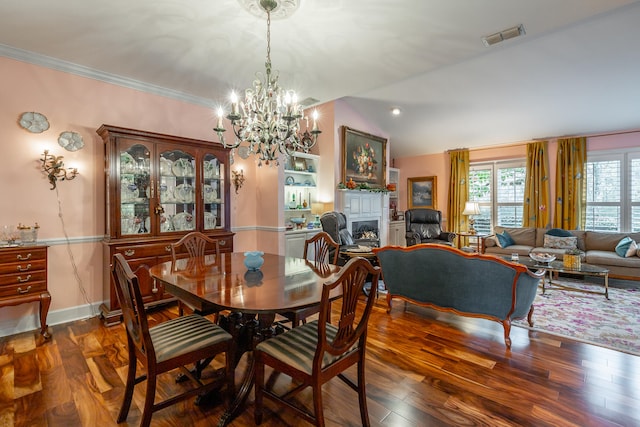 dining area featuring dark wood-type flooring, ornamental molding, vaulted ceiling, and a notable chandelier