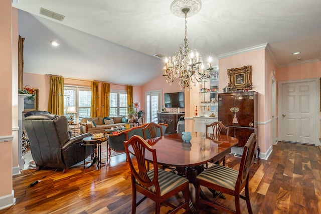 dining area with hardwood / wood-style floors, crown molding, vaulted ceiling, and a notable chandelier