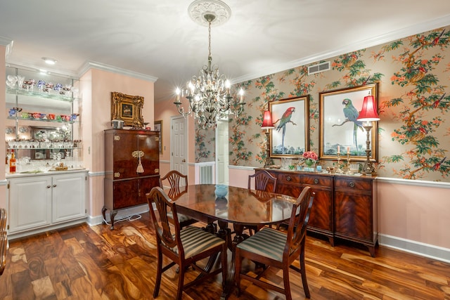 dining room featuring dark hardwood / wood-style floors, a chandelier, and crown molding