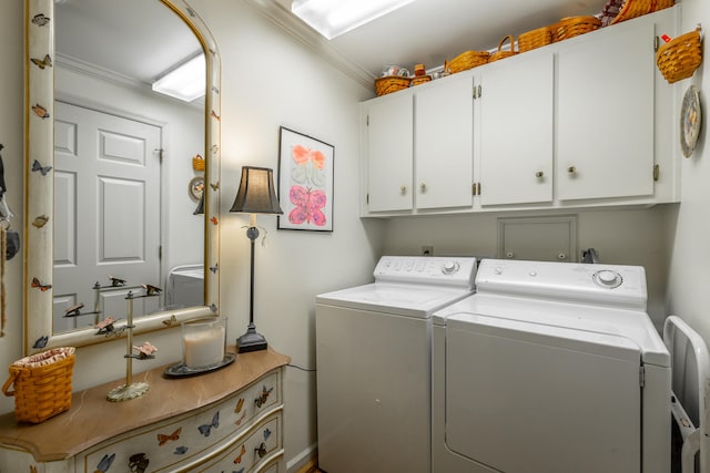 clothes washing area featuring washer and clothes dryer, cabinets, and ornamental molding