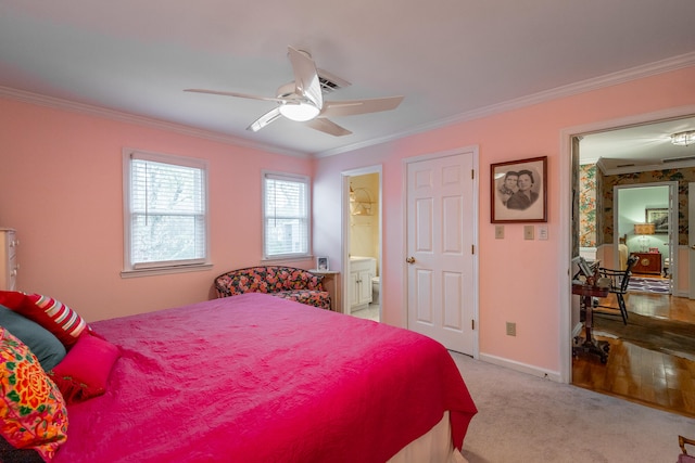 bedroom with ceiling fan, light colored carpet, ornamental molding, and ensuite bath