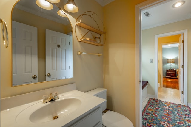 bathroom featuring wood-type flooring, vanity, toilet, and crown molding