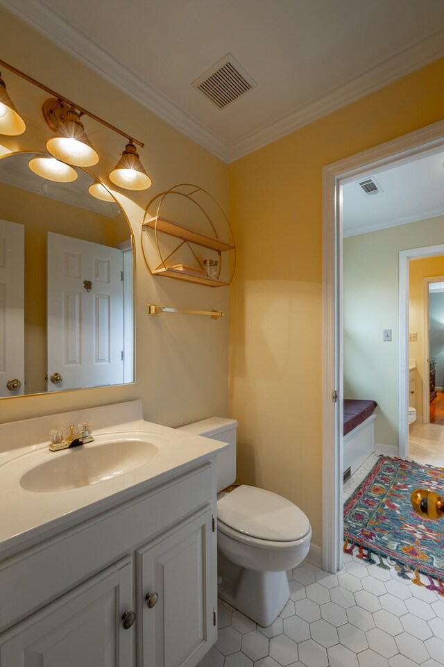 bathroom with toilet, vanity, tile patterned flooring, and ornamental molding