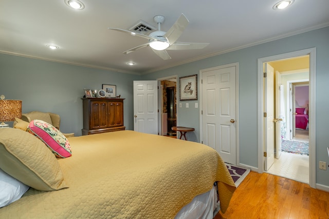 bedroom with hardwood / wood-style floors, ceiling fan, and crown molding