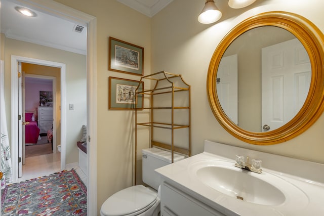 bathroom with vanity, toilet, and crown molding