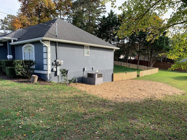 view of home's exterior with central AC and a yard