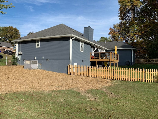 back of property with cooling unit, a yard, and a deck