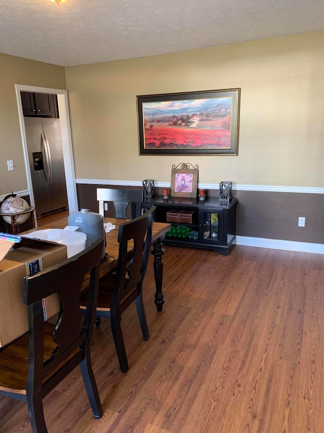 dining area featuring hardwood / wood-style flooring and a textured ceiling