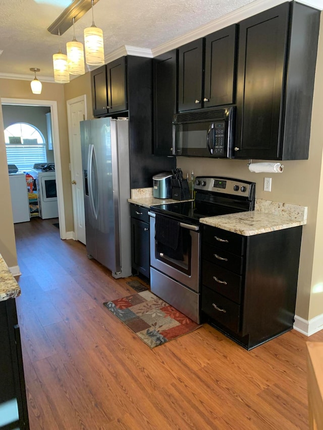 kitchen featuring stainless steel appliances, crown molding, light stone countertops, pendant lighting, and light hardwood / wood-style flooring