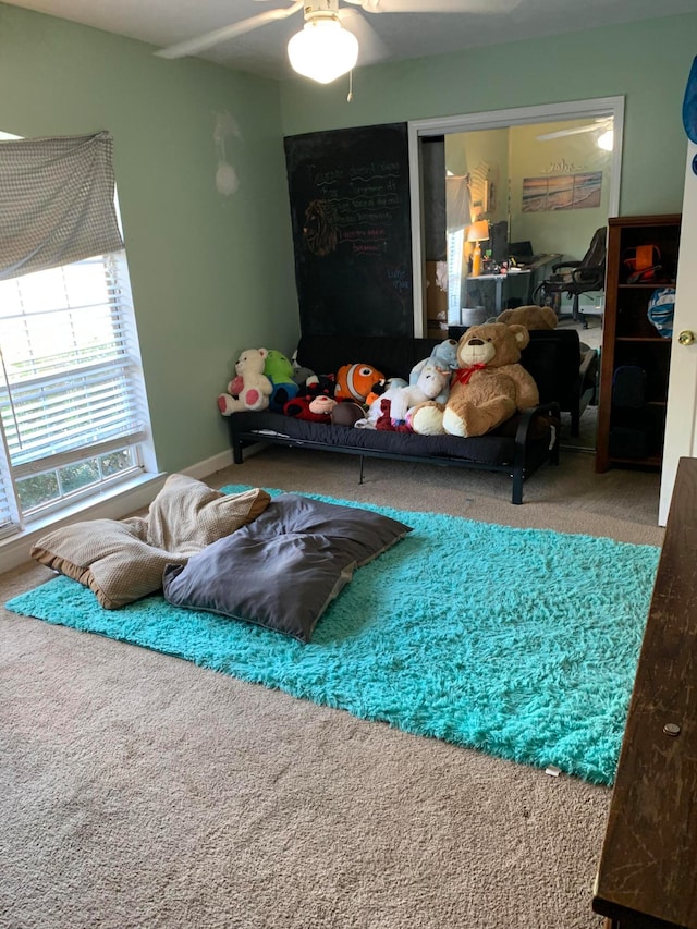 carpeted living room with ceiling fan