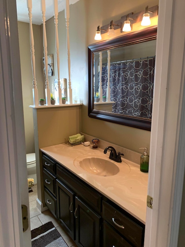 bathroom featuring tile patterned floors, vanity, and toilet