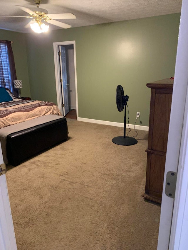 bedroom with a textured ceiling, carpet floors, and ceiling fan