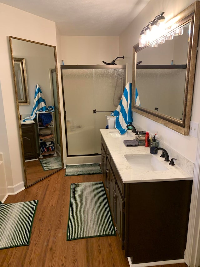 bathroom with vanity, an enclosed shower, and hardwood / wood-style floors