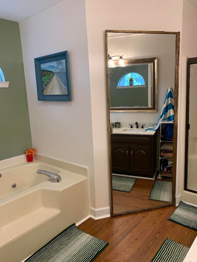 bathroom featuring a tub to relax in, vanity, and wood-type flooring