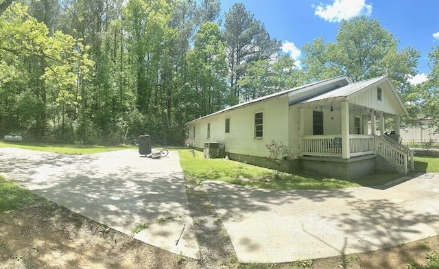 view of side of home featuring cooling unit and covered porch