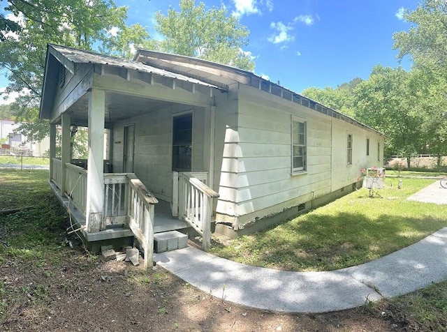 view of property exterior featuring covered porch and a yard