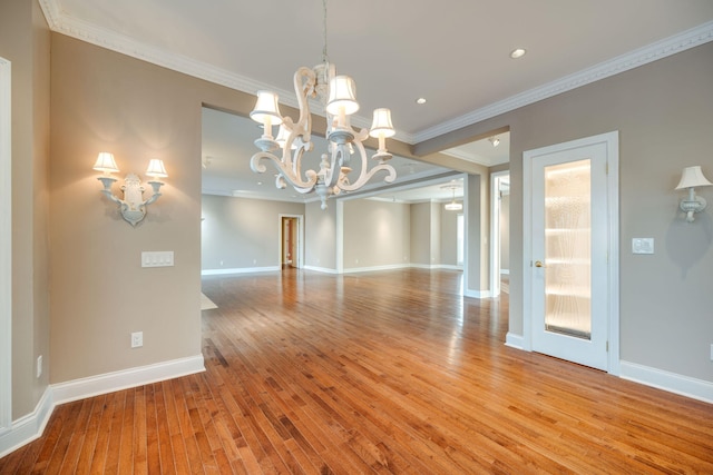 unfurnished dining area featuring ornamental molding, light hardwood / wood-style flooring, and an inviting chandelier