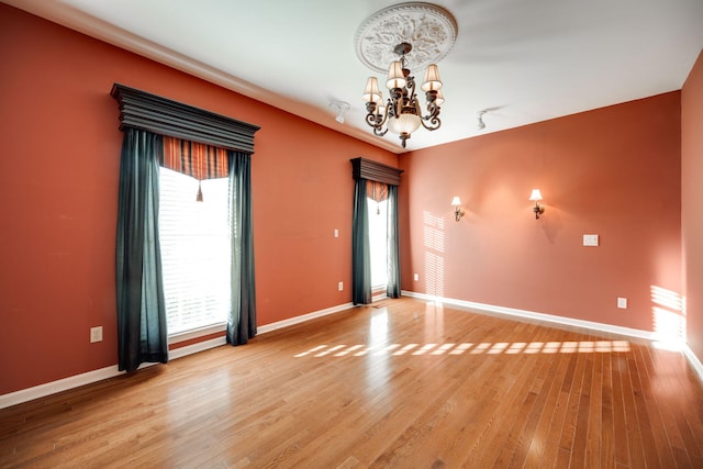 empty room with a chandelier and hardwood / wood-style floors