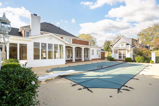 view of pool with a patio and a diving board