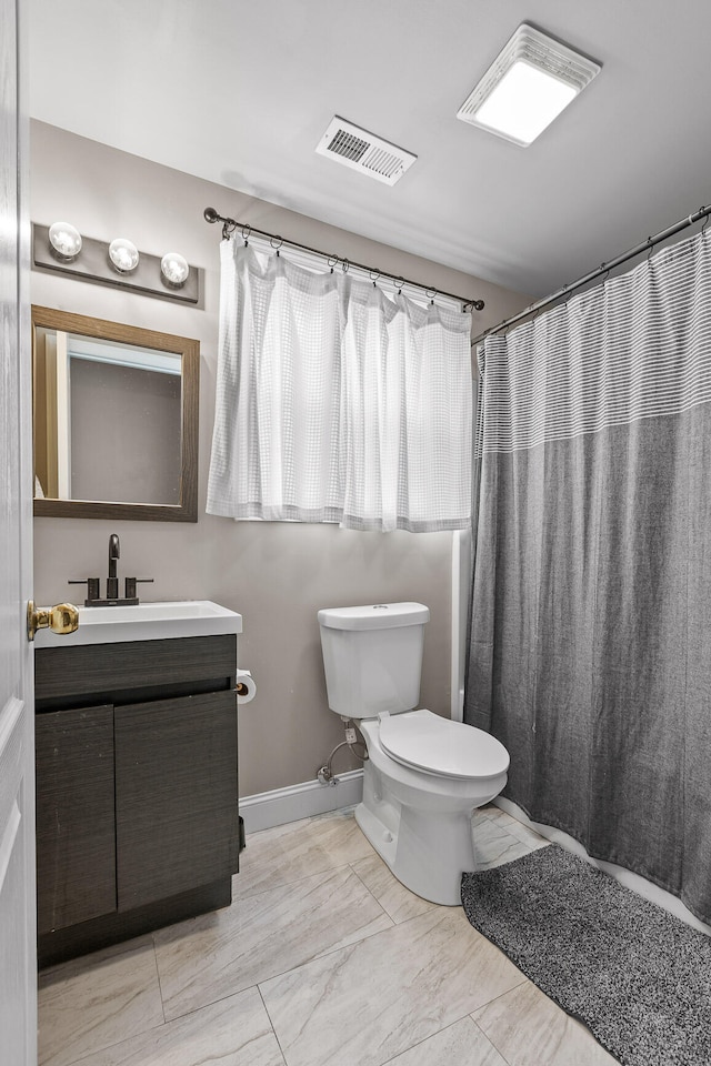 bathroom featuring curtained shower, vanity, and toilet