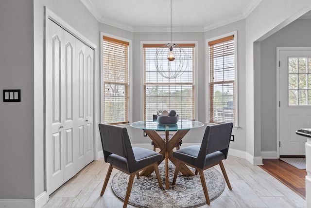 dining space with ornamental molding, a wealth of natural light, and light hardwood / wood-style floors