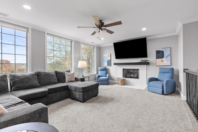 carpeted living room featuring ornamental molding, a brick fireplace, and ceiling fan