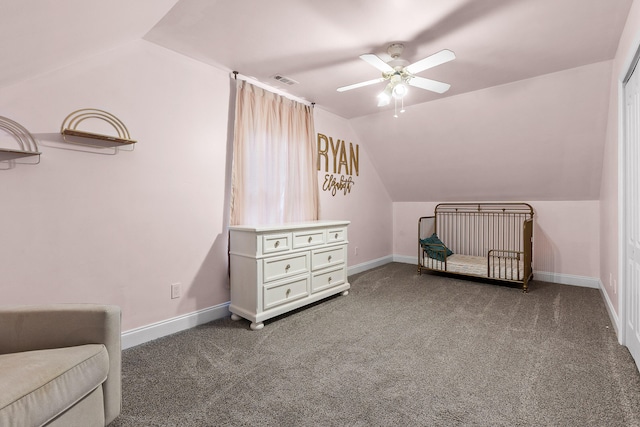 bedroom with a crib, ceiling fan, vaulted ceiling, and carpet floors