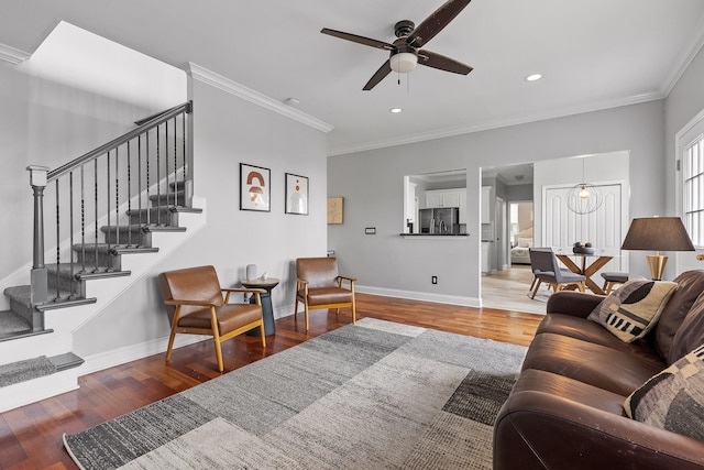 living room featuring hardwood / wood-style floors, ceiling fan, and crown molding