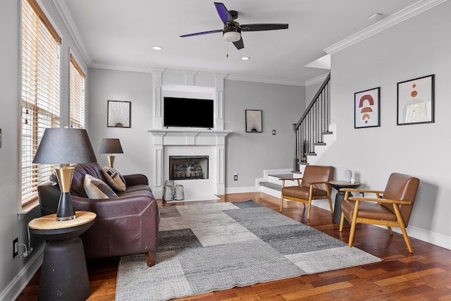 living room featuring ceiling fan, wood-type flooring, and crown molding