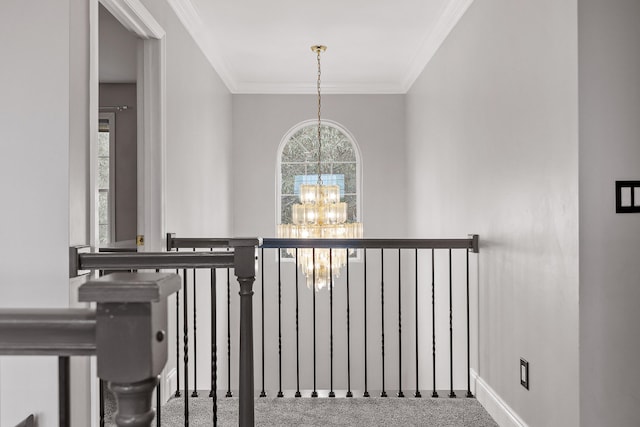 hallway featuring a chandelier, carpet flooring, and ornamental molding