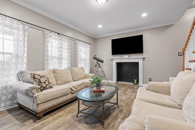 living room with light wood-type flooring and ornamental molding