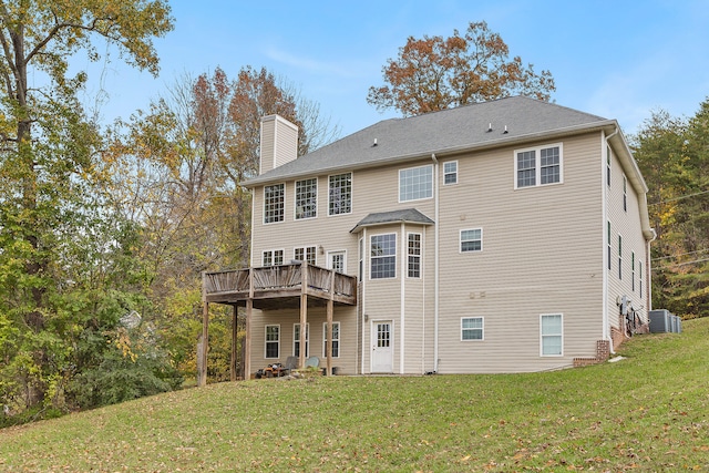 rear view of house with a wooden deck, cooling unit, and a lawn