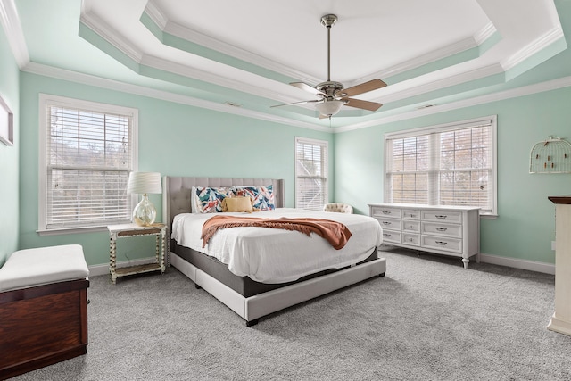 carpeted bedroom featuring a raised ceiling, multiple windows, crown molding, and ceiling fan