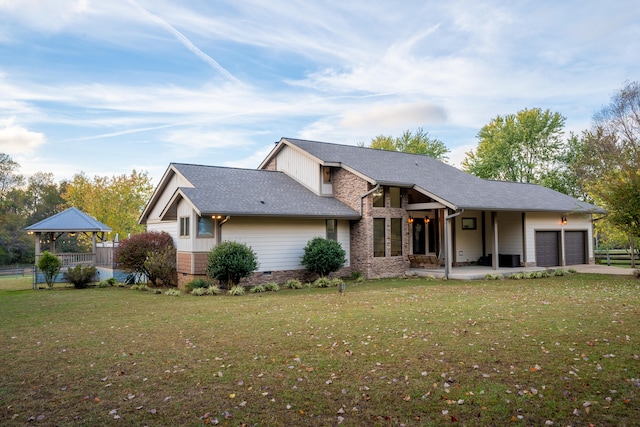 exterior space with a garage, a lawn, and a gazebo