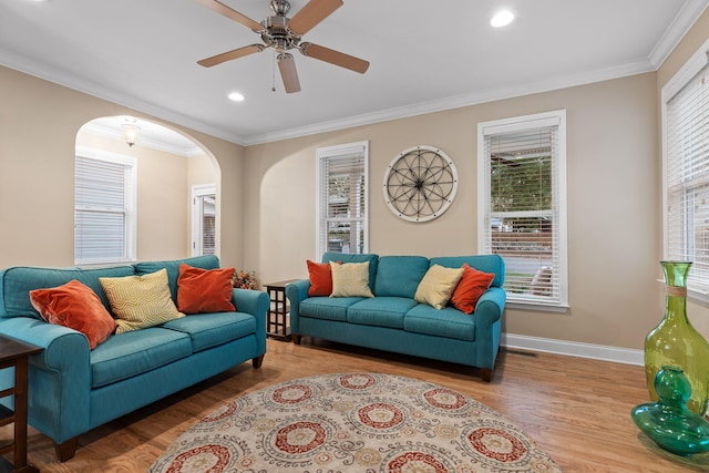 living room with light wood-type flooring, ceiling fan, and ornamental molding