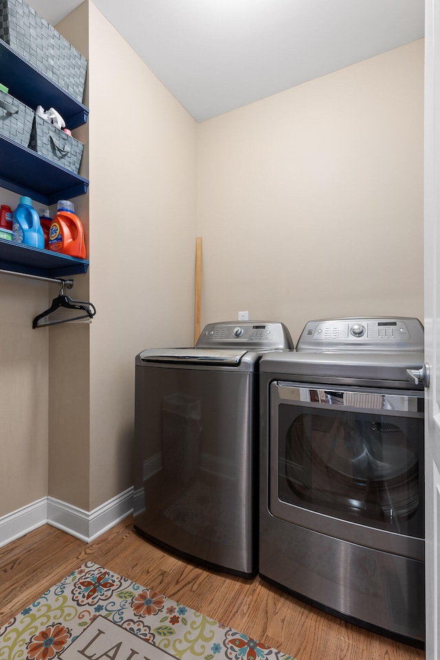 laundry room featuring separate washer and dryer and wood-type flooring