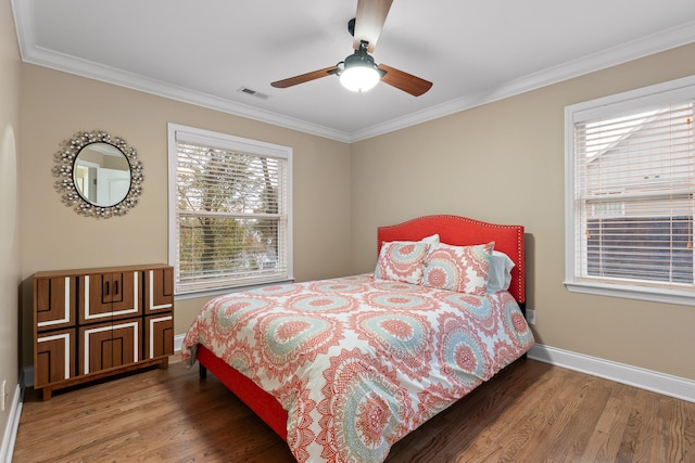 bedroom featuring multiple windows, hardwood / wood-style floors, ceiling fan, and crown molding