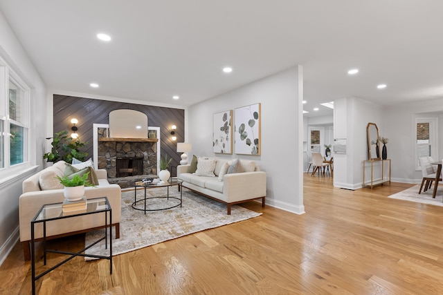 living room featuring a stone fireplace and light hardwood / wood-style floors