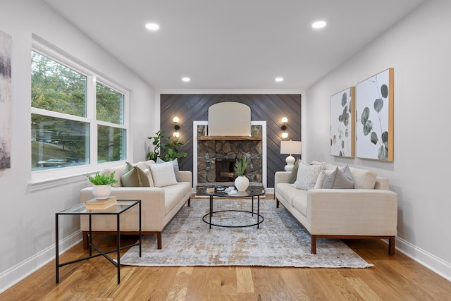 living room with a stone fireplace and hardwood / wood-style floors