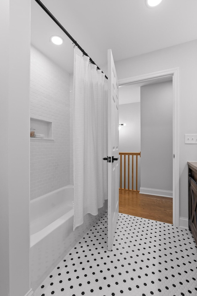 bathroom featuring wood-type flooring, shower / bath combo with shower curtain, and vanity