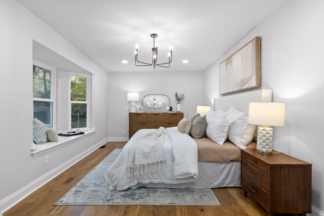 bedroom featuring dark hardwood / wood-style flooring and a notable chandelier