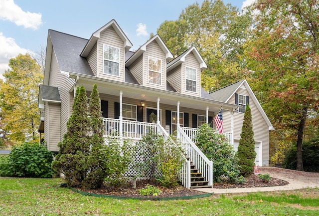 cape cod home with a garage, a porch, and a front yard