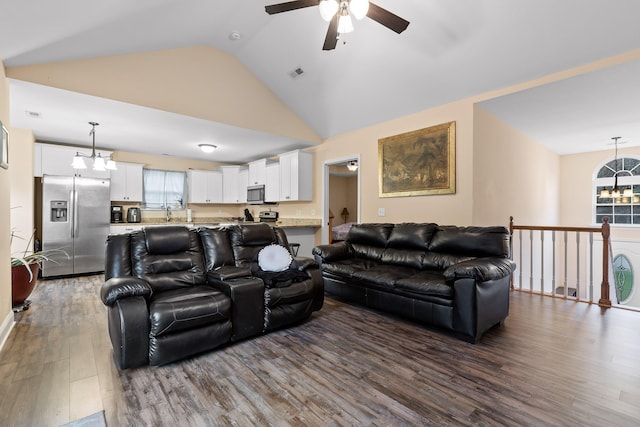 living room featuring dark hardwood / wood-style floors, ceiling fan with notable chandelier, and high vaulted ceiling