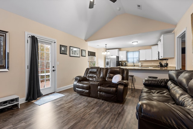 living room with dark wood-type flooring, ceiling fan, and high vaulted ceiling