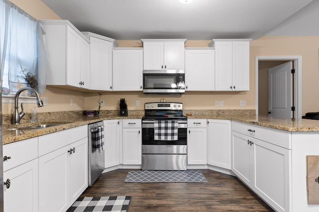 kitchen with stainless steel appliances, dark hardwood / wood-style flooring, sink, stone counters, and white cabinetry