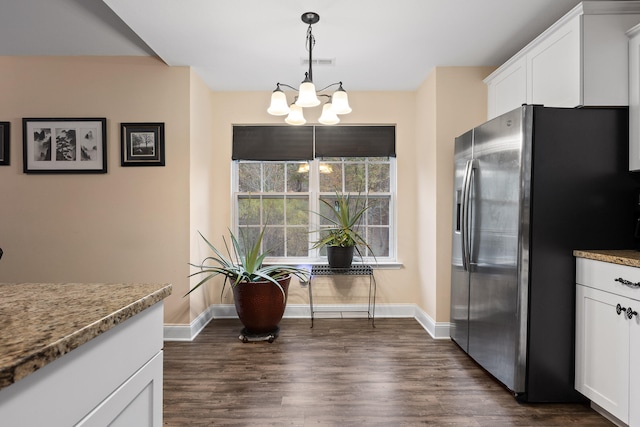 kitchen with white cabinetry, decorative light fixtures, stainless steel fridge with ice dispenser, dark hardwood / wood-style floors, and light stone countertops